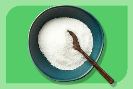 A bowl of kosher salt with a wooden spoon