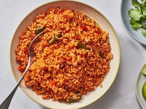 A large bowl of Mexican Red Rice served with cilantro and limes