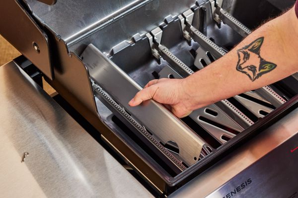 Hand lifting a component out of the Weber Genesis EX-325S Propane Gas Smart Grill