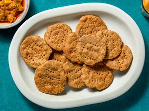 A platter of mathri, served with chai tea and chutney