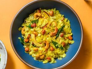 A blue bowl of poha chivda, with a smaller bowl in the corner of the frame