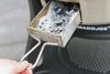 A person pulling out coals on a Kamado Konnected Joe grill