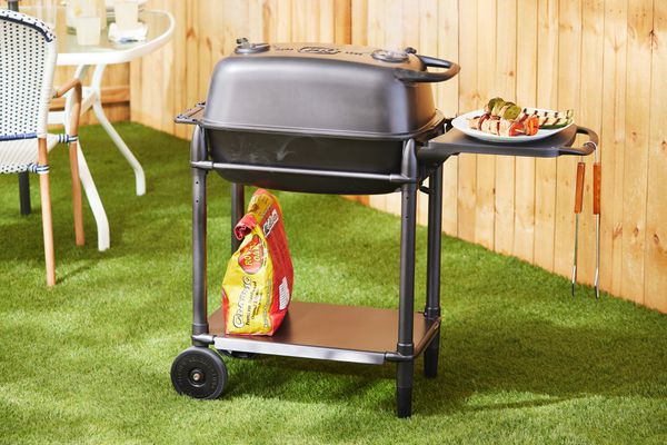 A PK Grills PKGo Camp & Tailgate Grilling System in a yard