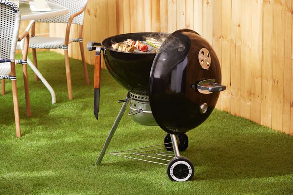 Weber Original Kettle Premium 22-Inch Charcoal Grill on grass in a backyard