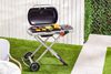 Weber Traveler Portable Gas Grill with food being grilled in backyard 