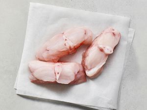 Three fillets of monkfish on parchment paper