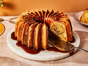 Whiskey cake with a brown butter whiskey glaze on a serving platter, with a slice removed