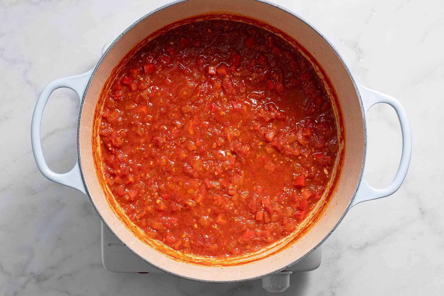 Tomato sauce cooking in a pot on a burner 