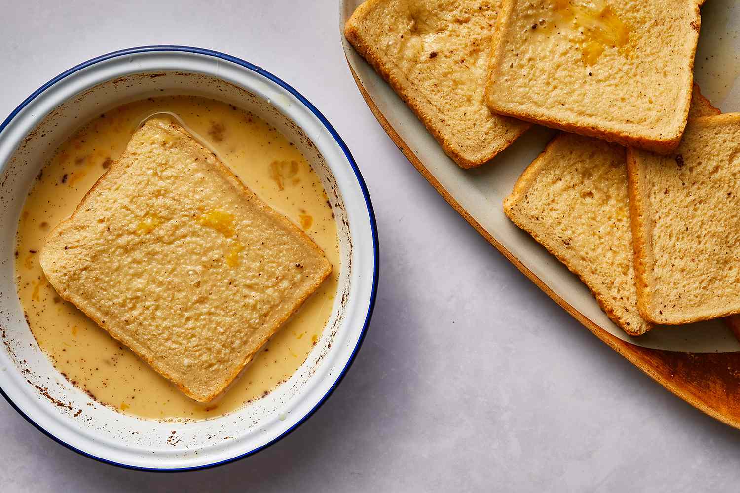 Slice of bread in a bowl with the egg mixture and bread slice on a plate