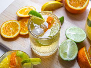 Simple white wine sangria surrounded by slices of lemons, limes, and oranges