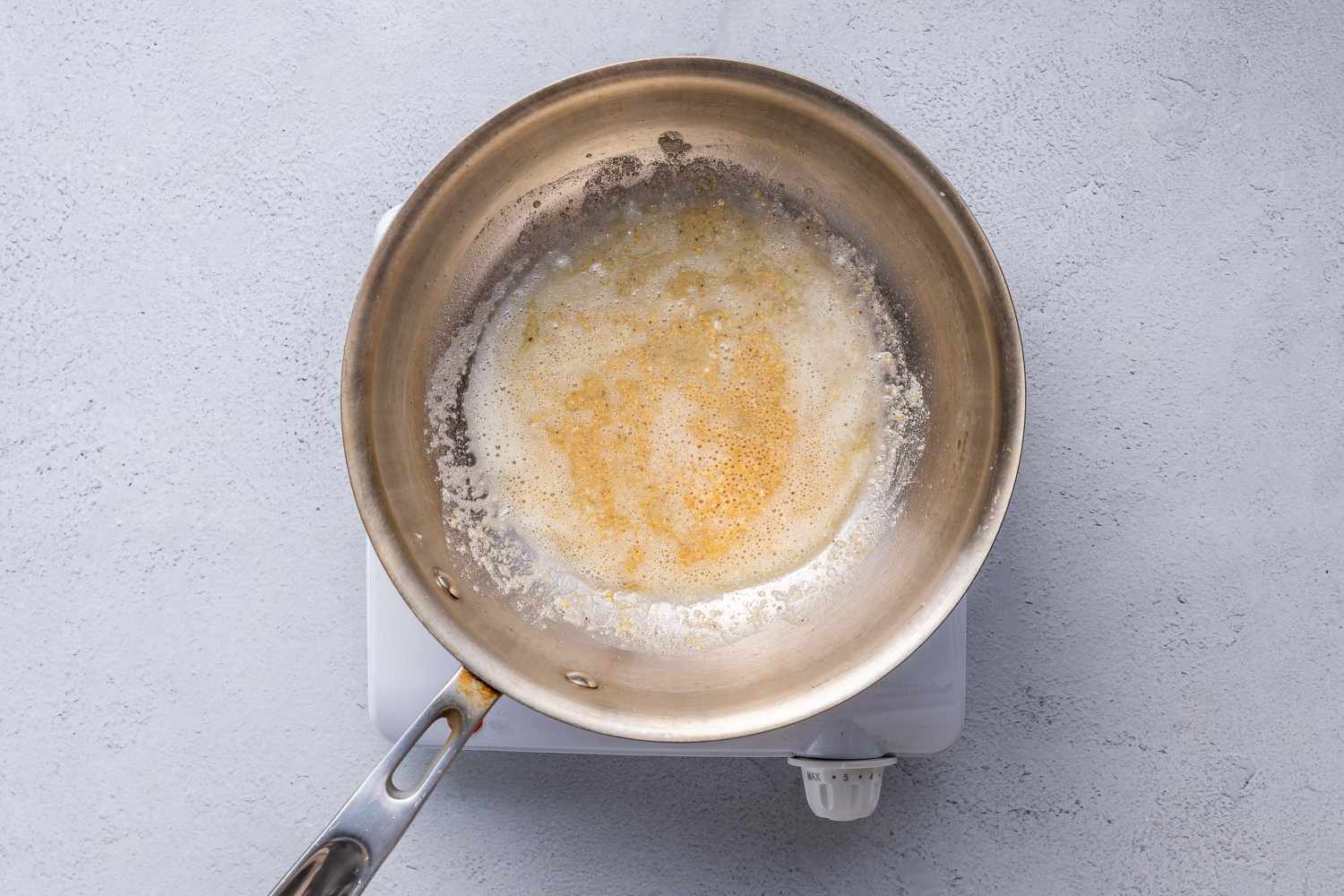 Flour, mustard, and black pepper with melted butter in a pan