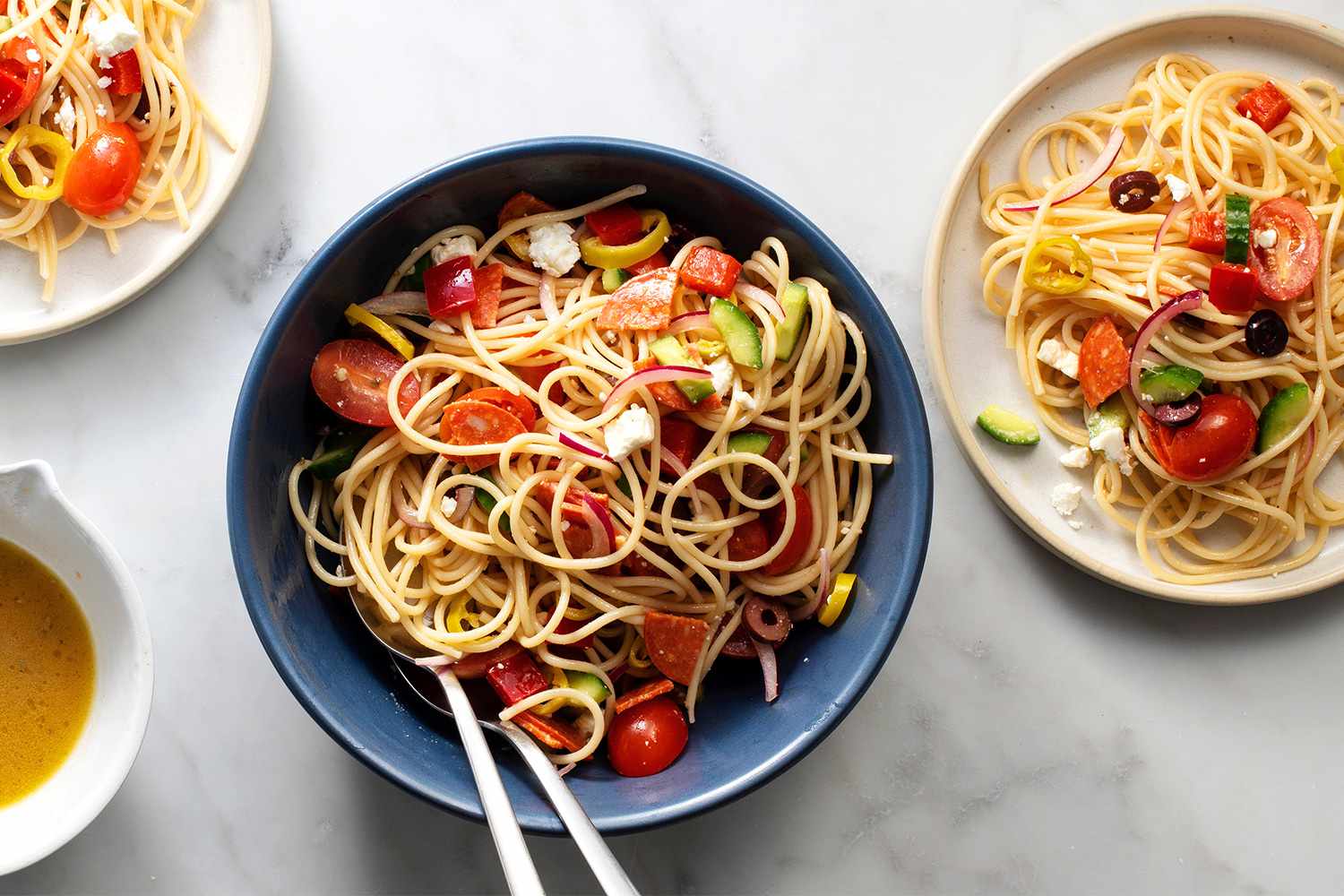 Spaghetti salad in a bowl and on plates 