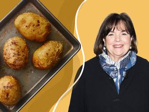 Ina Garten next to a pan filled with baked potatoes 