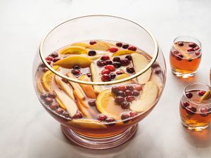 Thanksgiving punch in a glass punch bowl with glasses of punch nearby