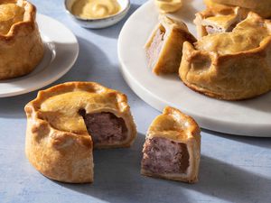 Traditional Hand-Raised Pork Pies cut open and on white plates