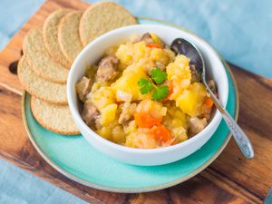 Traditional Scottish stovies recipe in a bowl with oatcakes served alongside