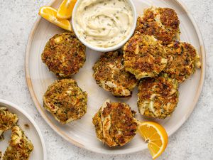 Vegan "Crab" Cakes on a platter, served sauce and orange wedges 