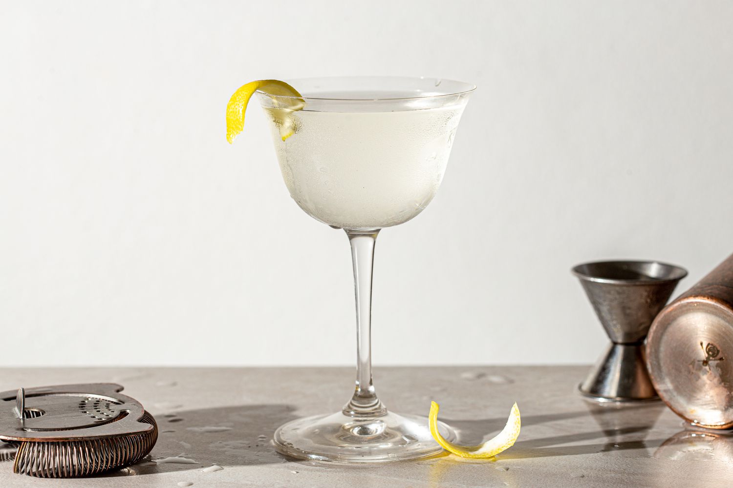 Vodka martini in a glass garnished with a lemon peel