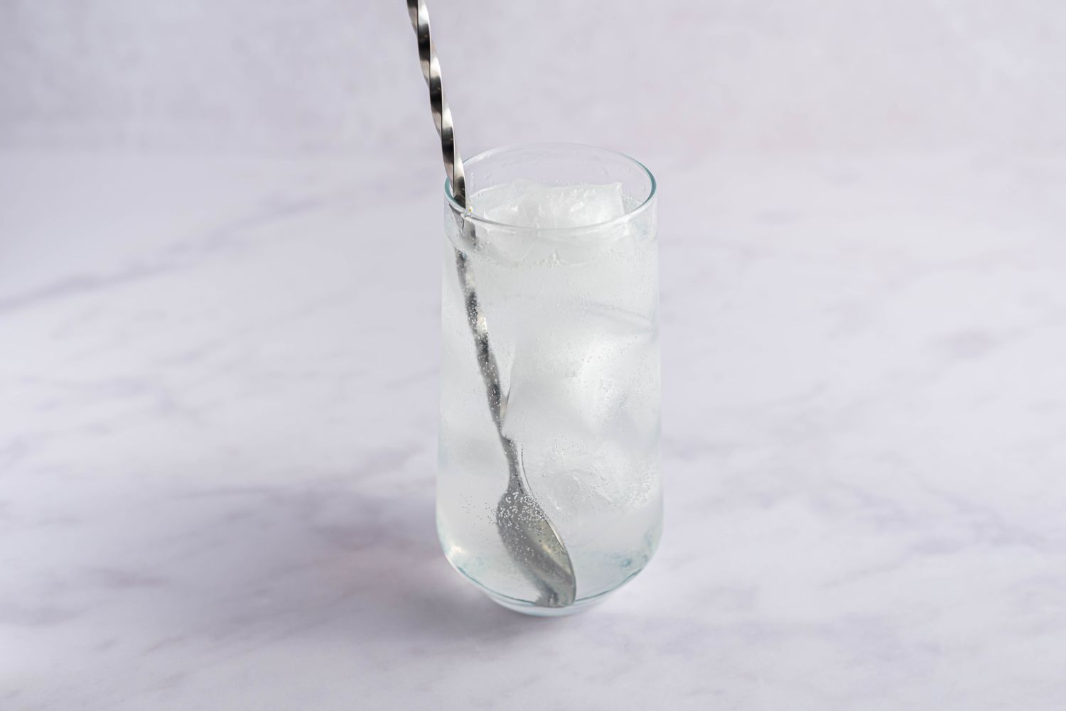 Glass filled with tonic and stirred with a spoon