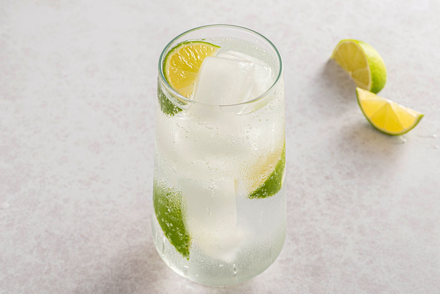 Vodka tonic served with lime wedges