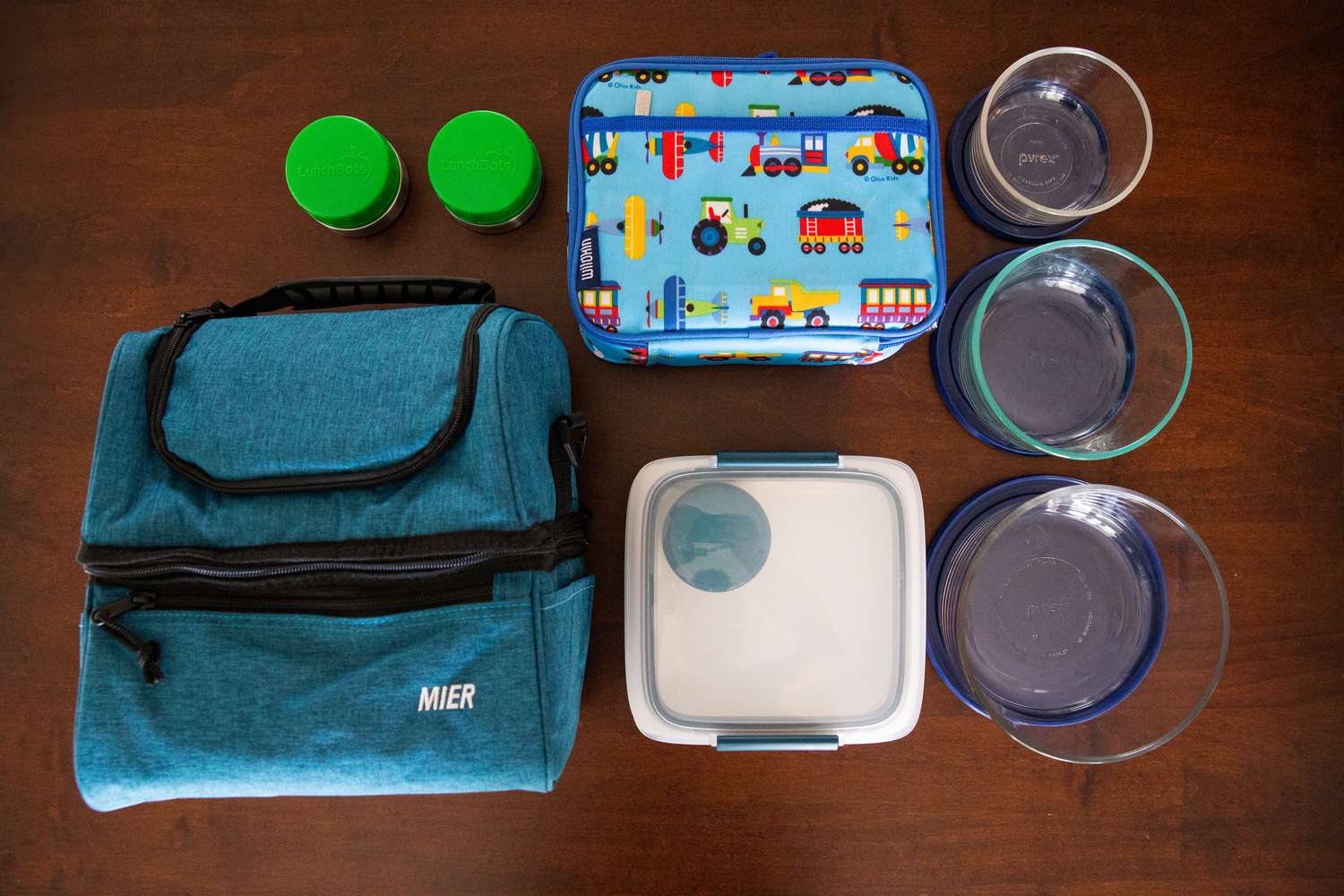 Assortment of recommended lunch containers displayed on a wooden surface