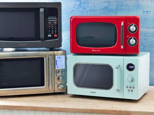 Several of the best microwaves we recommend displayed on a wooden counter