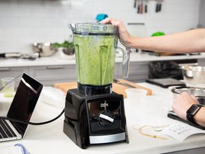  Person using the Vitamix 2300 to blend a green smoothie